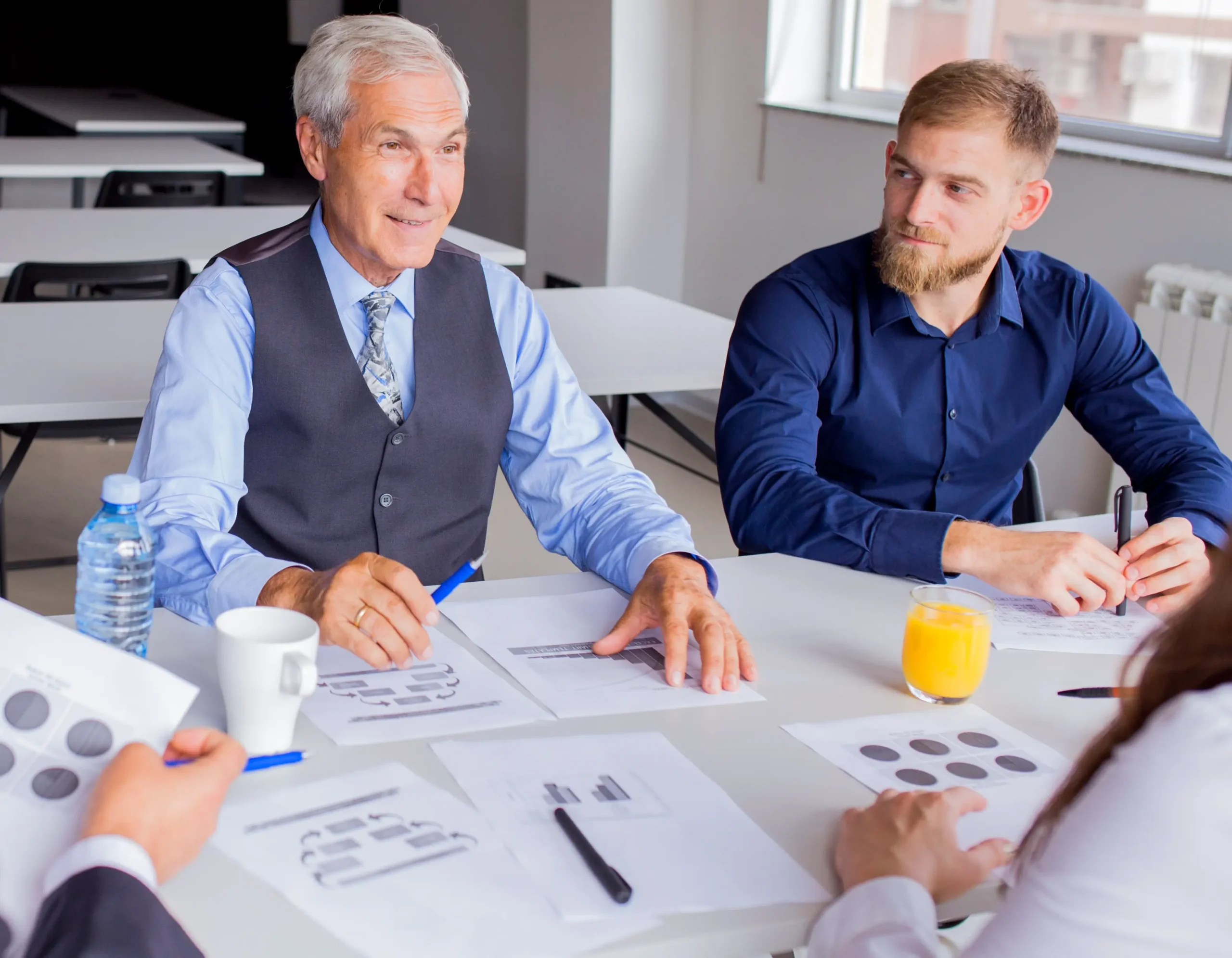 Senior executive leading strategy discussion with team around conference table
